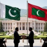 Editorial illustration of the Pakistani and Maldivian flags flying side by side on flagpoles in front of a government building in Islamabad while two suited officials exchange a signed document folder at a ceremony, with photographers in the foreground