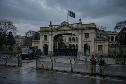 Security personnel near barbed-wire barricades outside a Khyber Pakhtunkhwa government building in Peshawar after CM Sohail Afridi was taken into preventive custody in October 2026