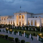 Government secretariat building in Peshawar at dusk with Pakistani flags as Dr Fakhr Alam Irfan takes charge as Khyber Pakhtunkhwa's new chief secretary in October 2026
