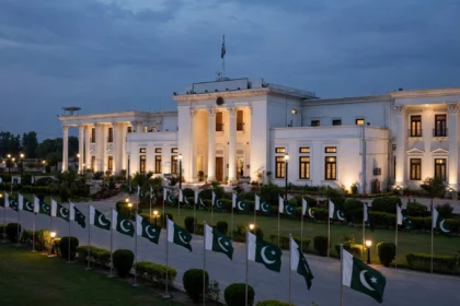 Government secretariat building in Peshawar at dusk with Pakistani flags as Dr Fakhr Alam Irfan takes charge as Khyber Pakhtunkhwa's new chief secretary in October 2026