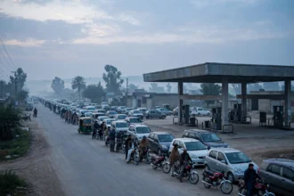 Cars and motorbikes queuing at a petrol station in Pakistan at dawn